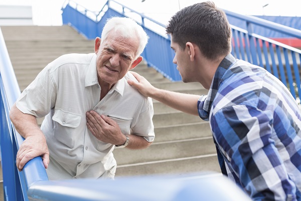 old man having chest pains collapsing near another man