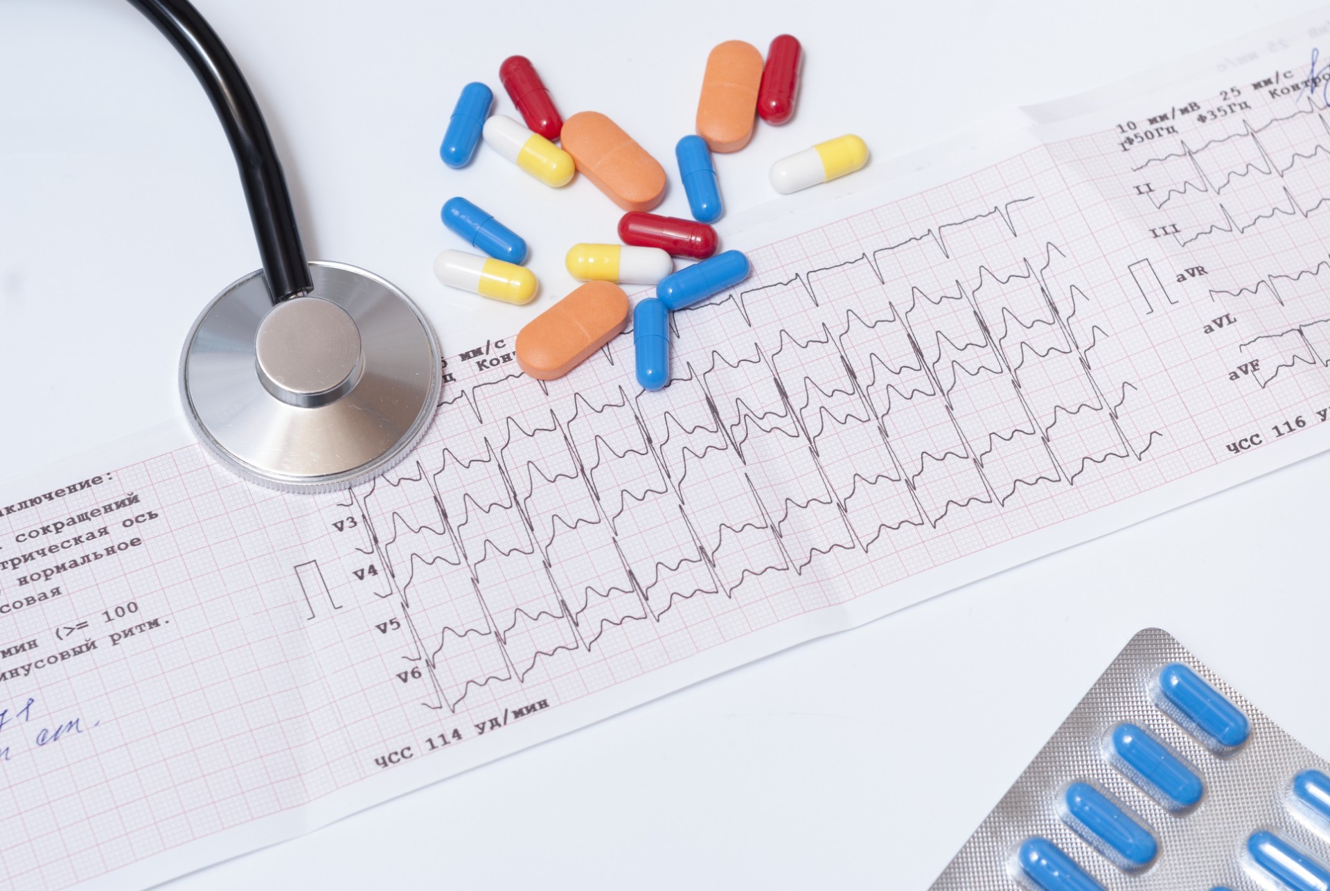 medical pills, stethoscope and electrocardiogram results on the table