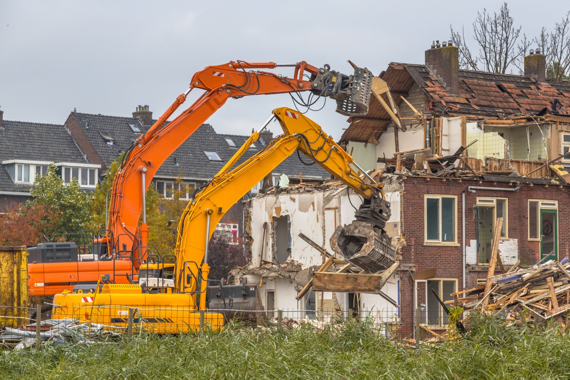 Two Demolition cranes demolishing old row of houses in the Netherlands